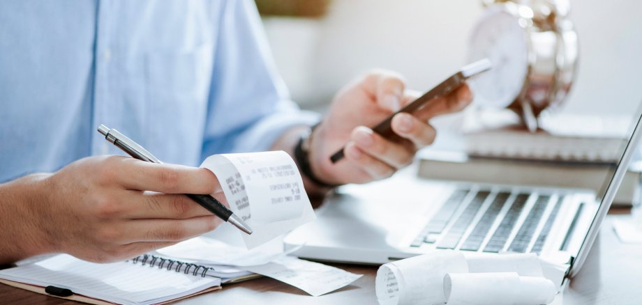 young man holding pen with bills working for calculate business data, taxes, bills payment, Start up counting finance. accounting, statistics, and analytic research concept