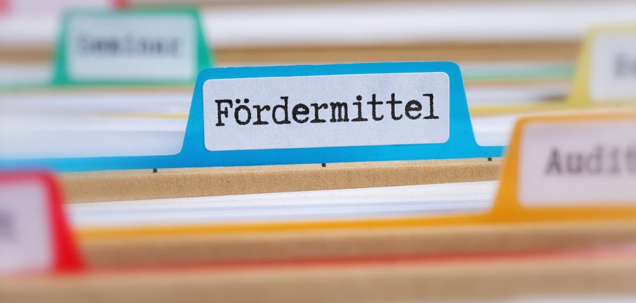 File folders with a tab labeled Funding in german - Fördermittel