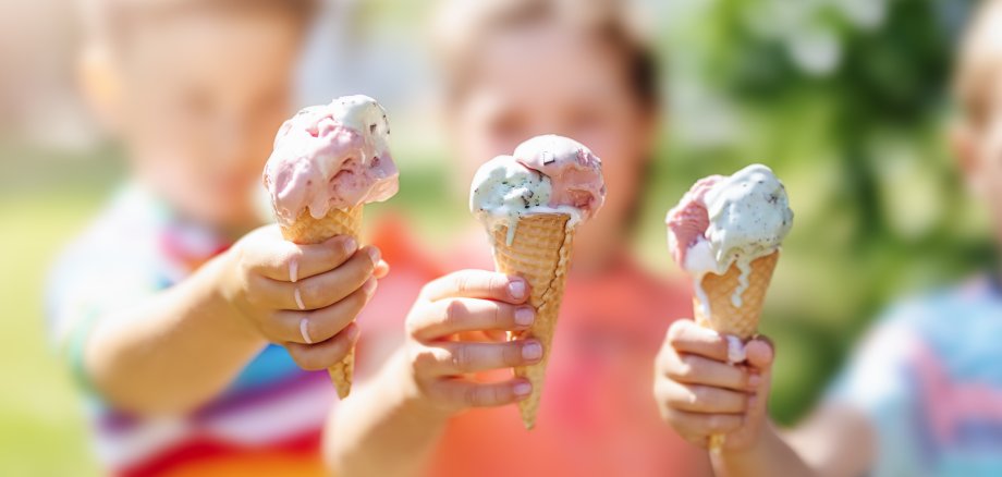 Group of children in the park eating cold ice cream.