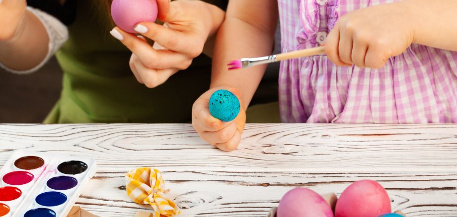 Mother and daughter coloring eggs for Easter